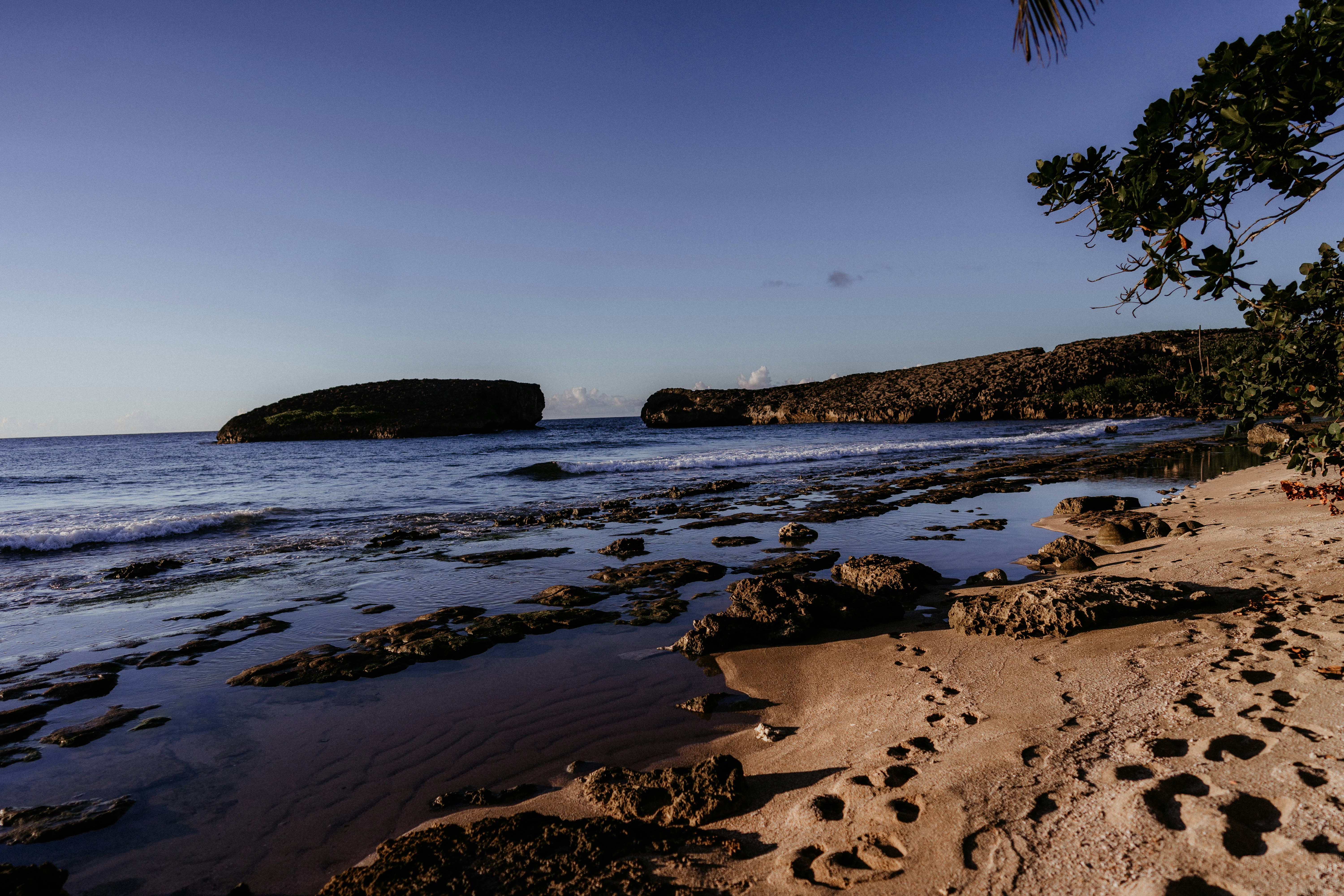 brown rock formation on body of water during daytime